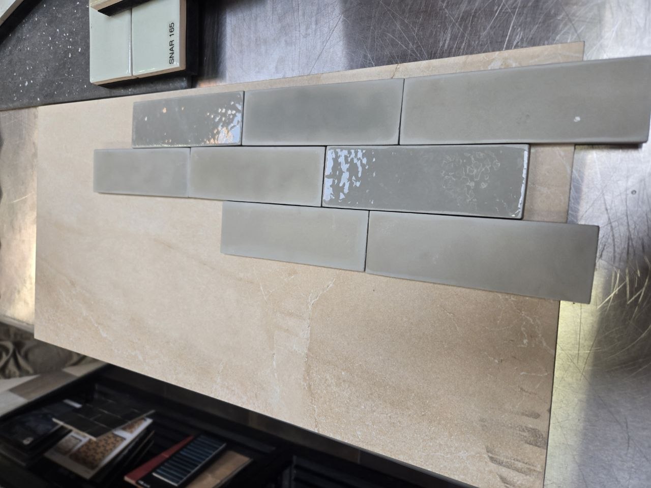 Muted green-gray glossy tile on beige slab