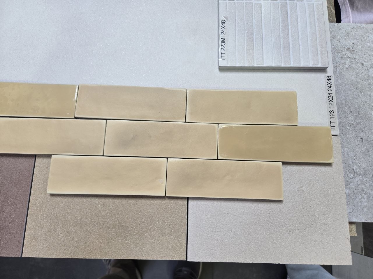 Yellow / brownish-yellow subway tile samples compared with gray, taupe, and textured tile boards