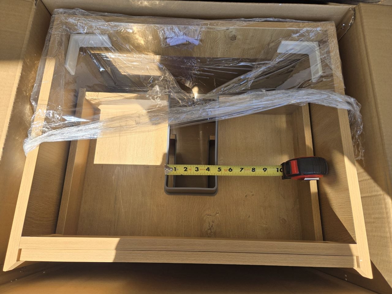 24 inch Sottile vanity in garage with tape measure across drawer plumbing slot